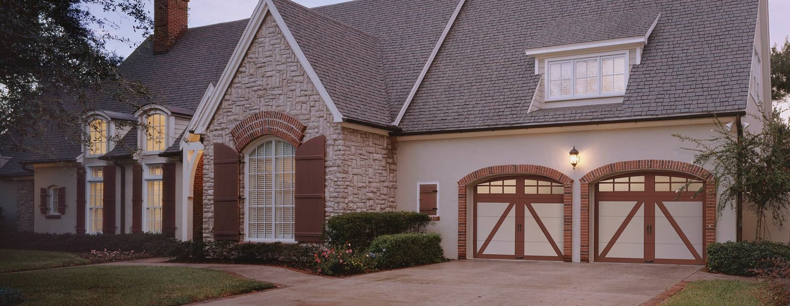Brick home with arched carriage-style garage doors